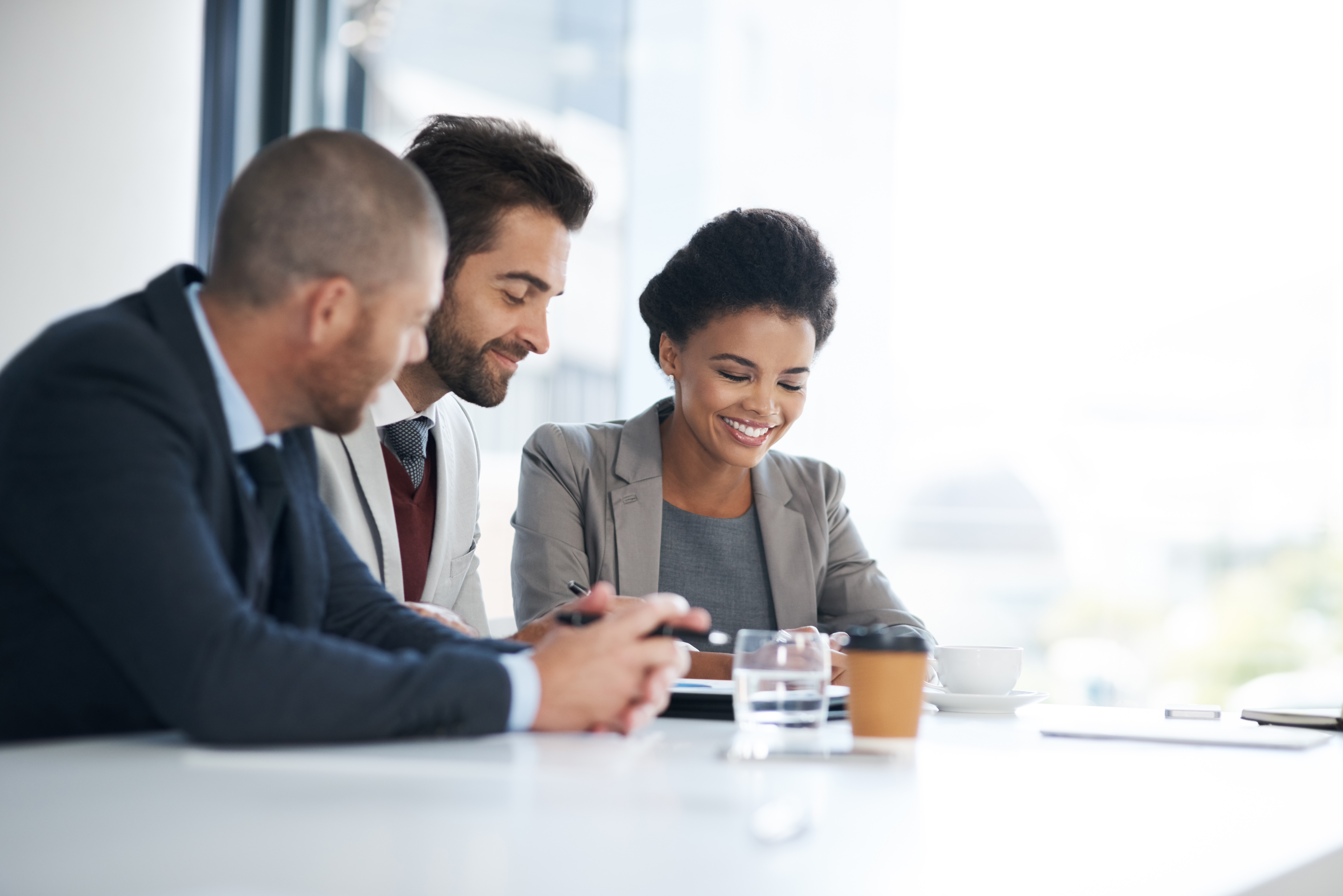 Three People Sitting Discussing By A Window